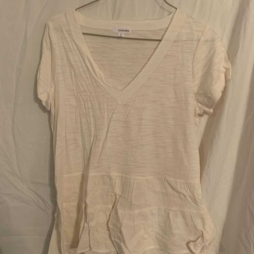 White T-shirt with a ruffled bottom.